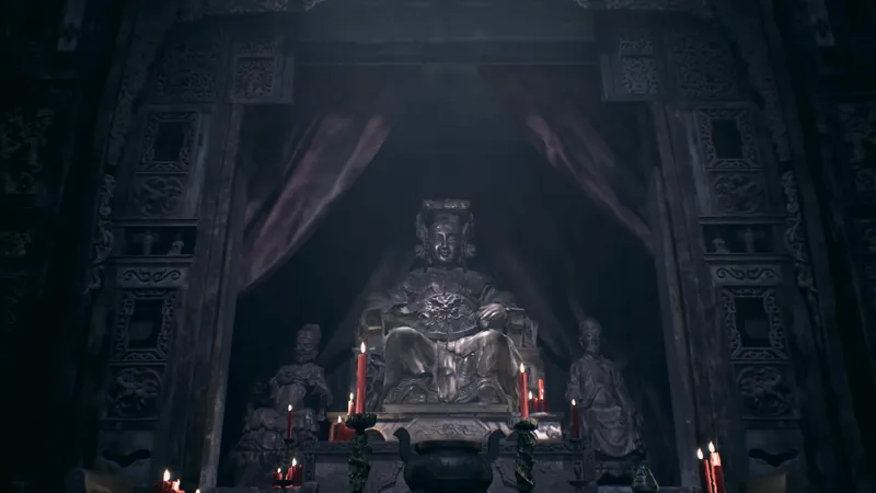 A seated statue with red candles.
