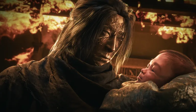 Close-up of a man holding a baby, fire behind.