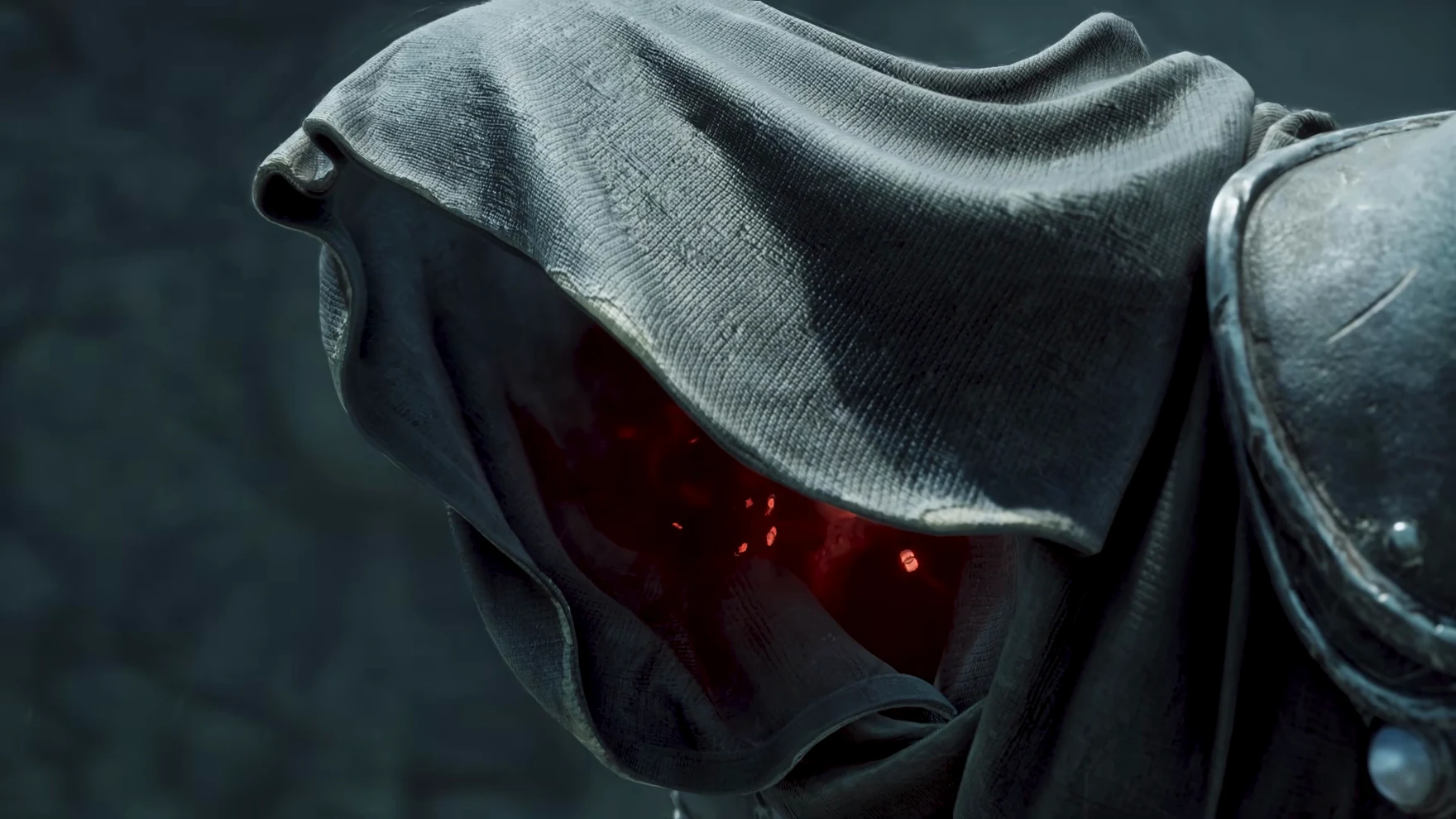 Close-up of a grey hood with red glowing points inside.