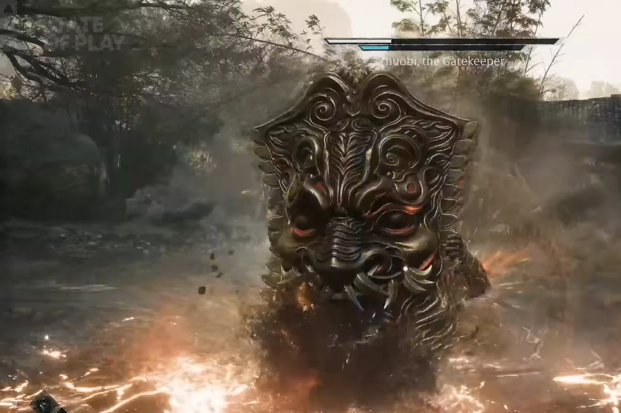 A huge carved shield with a beast face fills a village yard.