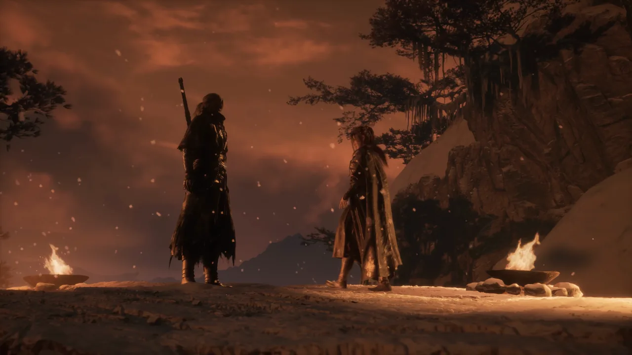 Two figures stand apart on a snowy ledge at dusk, with small fires on the ground and pine trees behind.