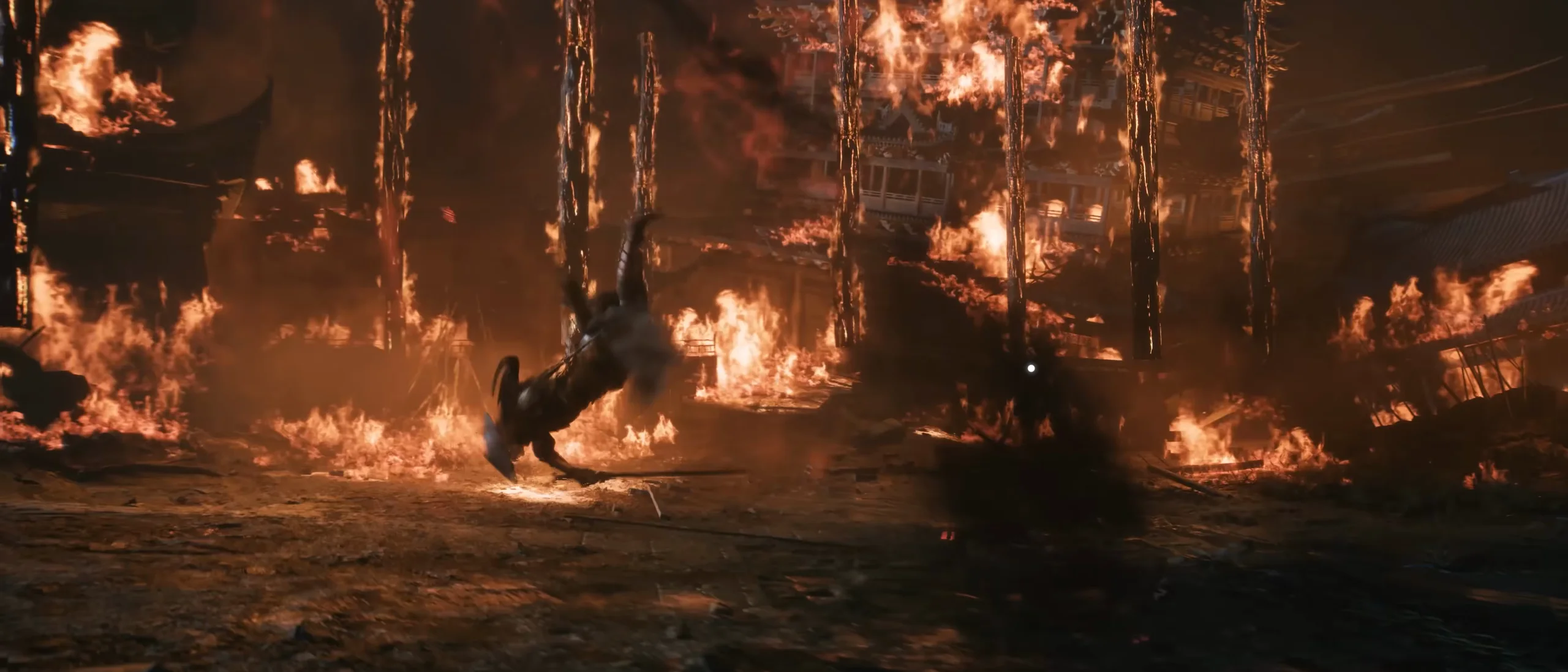 Columns of fire rise across a burning yard; a figure among them.