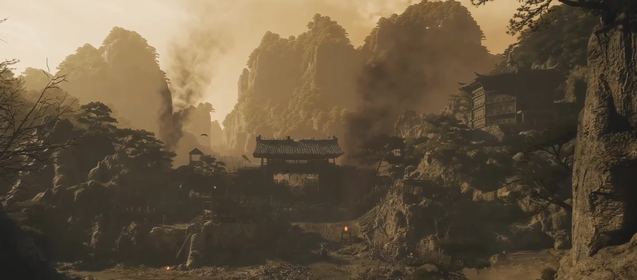 A wide valley of rocks, trees and tiled roofs in warm haze.