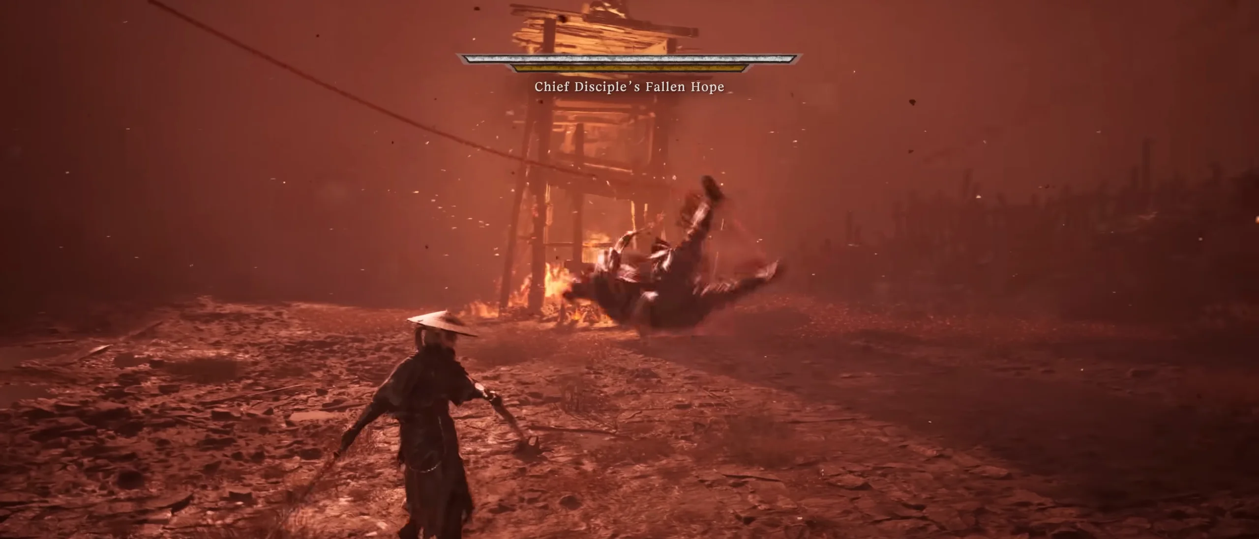 Under a red sky a pale figure is upside down in mid-air beside a burning tower; a figure in a straw hat stands below; a name plate at the top.