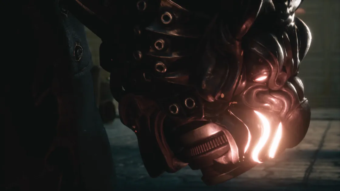 A dark metal mask with glowing orange slits, close up.