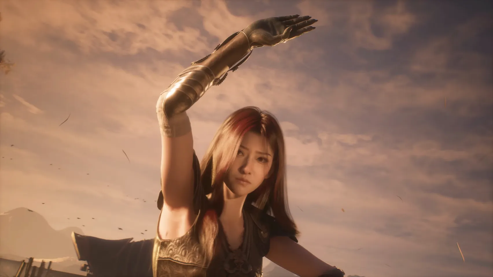 A woman with red streaks in her dark hair raises one arm in a golden field.