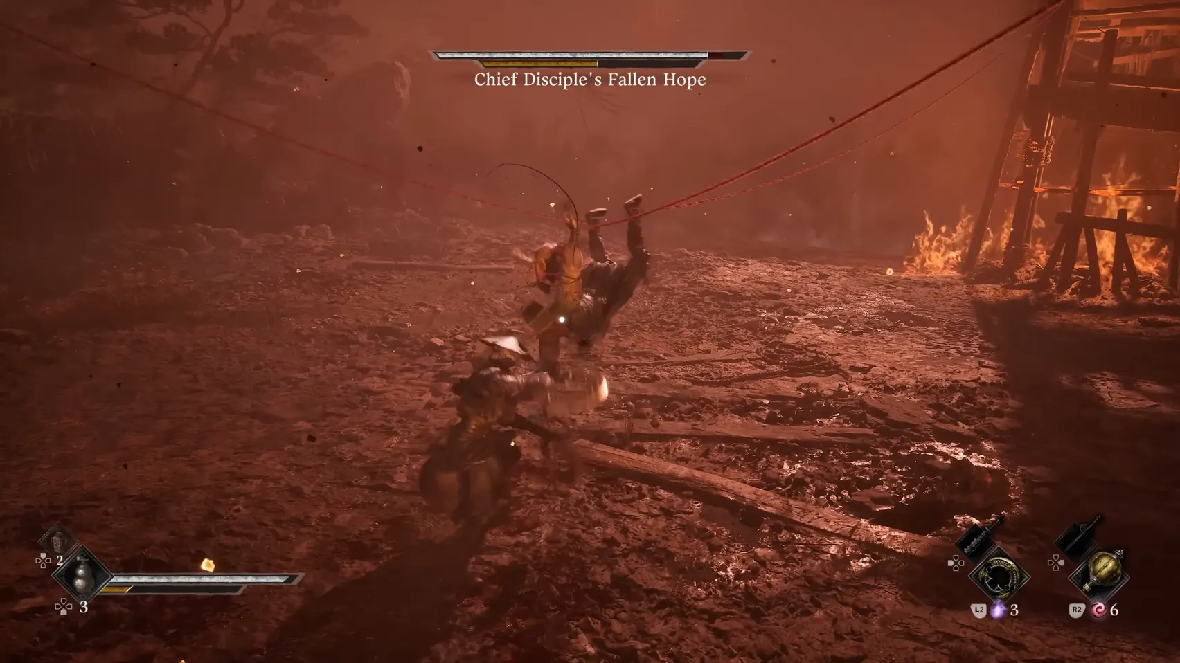 A figure hanging from a red thread swings down at a figure in a red-lit yard by a burning tower.