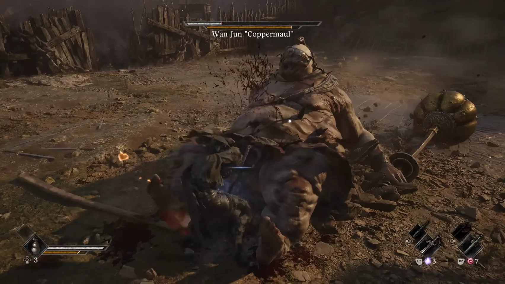 A heavy figure lies on his back in the dirt beside a golden hammer, a figure pressed against his side.