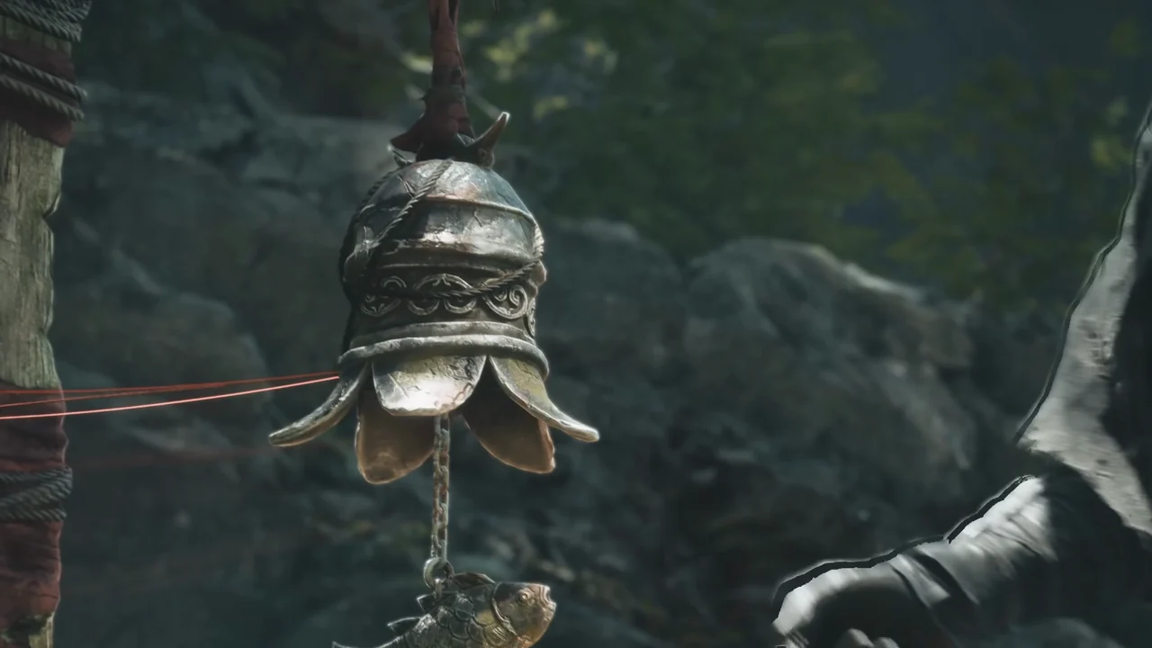 A bronze bell with a petal-shaped rim hangs beside a rope-bound wooden post.