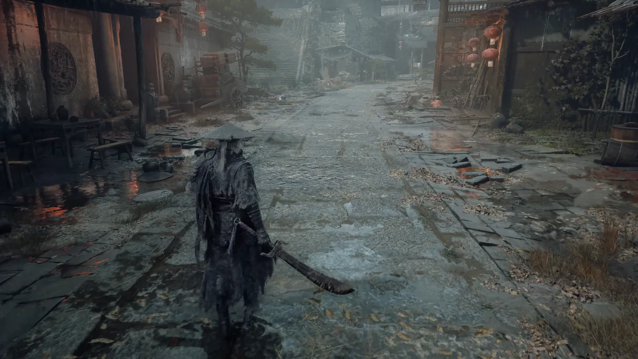 A cloaked figure in a straw hat walks down a wet stone street between wooden houses with red lanterns.